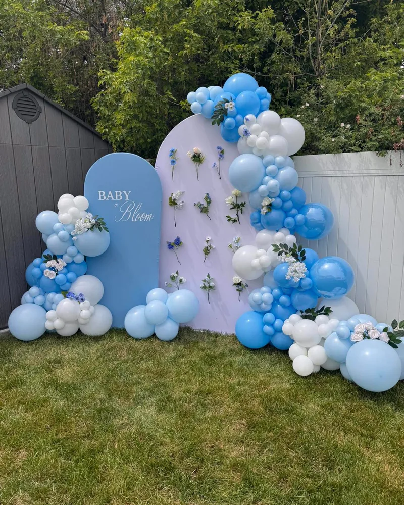 A Baby in Bloom baby shower with blue and white balloons and fresh flowers