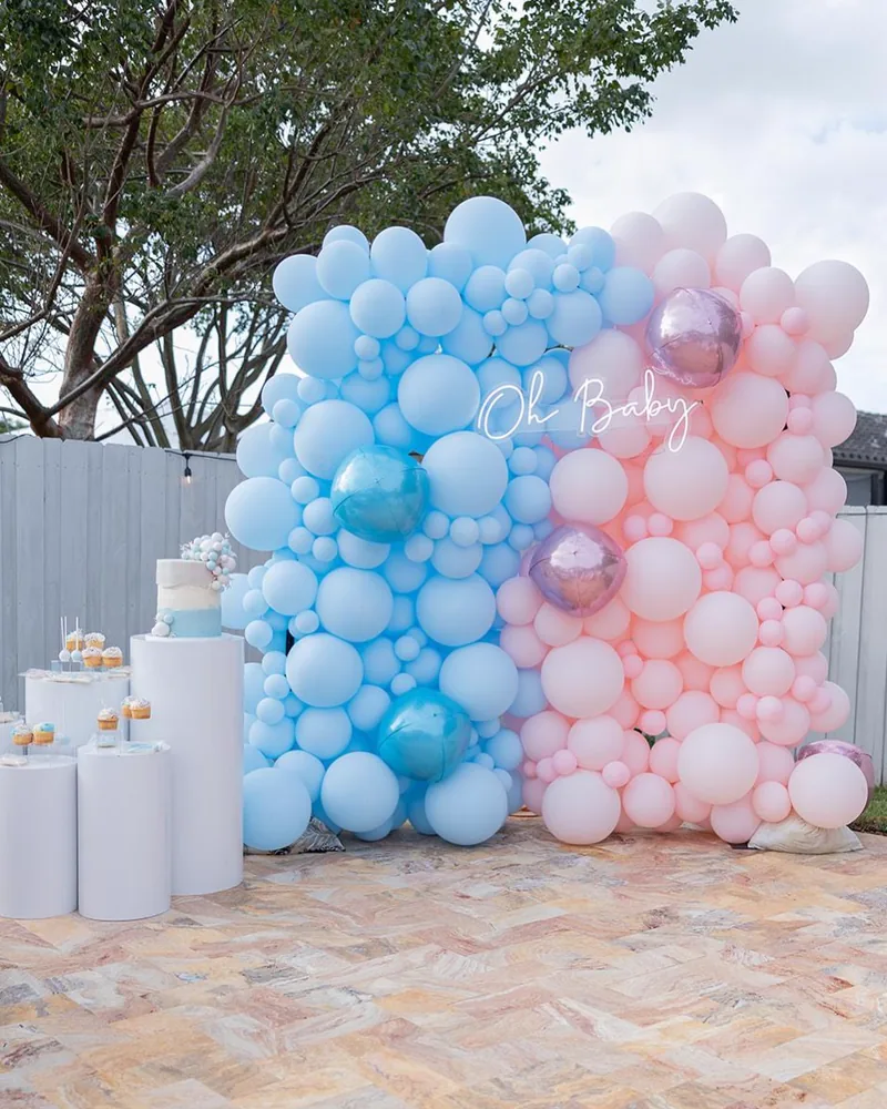 Cake and dessert plinths in front of a balloon wall