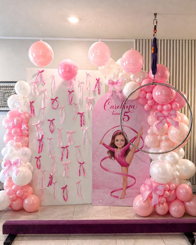A custom printed panel and a ribbon wall at a gymnastics themed party